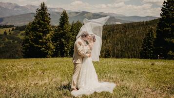 Un couple s’embrasse dans un champ, avec une chaîne de montagnes en arrière-plan.
