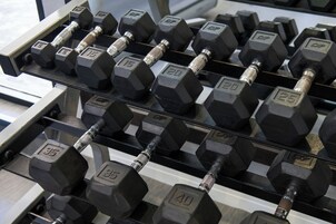 A rack of hexagonal dumbbells with weights ranging from 5 to 40 kilograms.