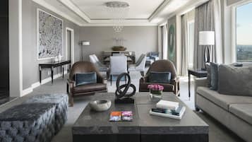 A modern living room with a sofa, two armchairs, a coffee table, and a chandelier.
