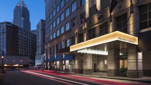 A hotel with a prominent marquee sign, multiple flags, and a modern architectural design.