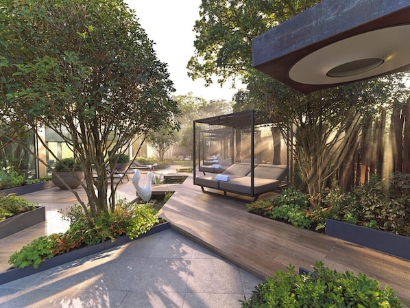 Un área moderna para relajación al aire libre con mobiliario y una estructura de pérgola.