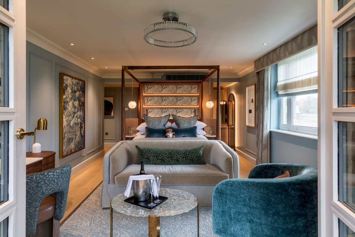 Ein modernes Hotelzimmer mit einem großen Bett, einer Sitzecke mit Tisch und Blick nach draußen.