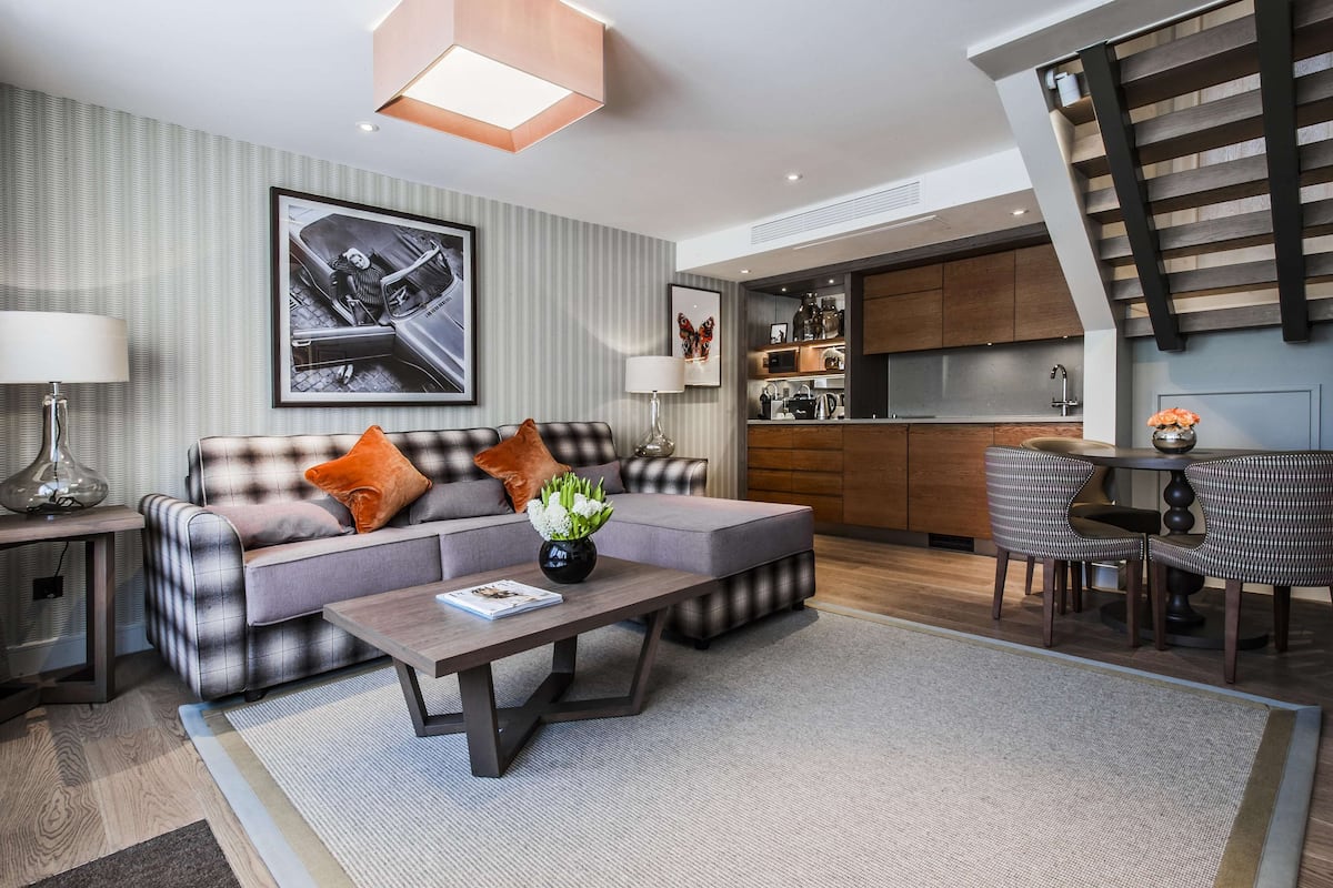 Ein modernes Wohnzimmer mit einer Couch, einem Couchtisch und einem Essbereich mit Stühlen.