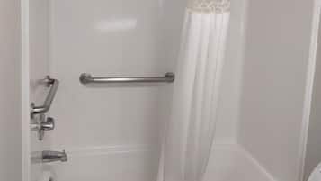 A bathroom with a bathtub, a shower curtain, and a toilet.
