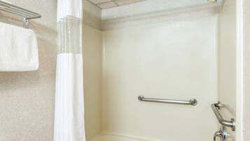 Un baño con una bañera, cortina de ducha y un perchero para toallas.