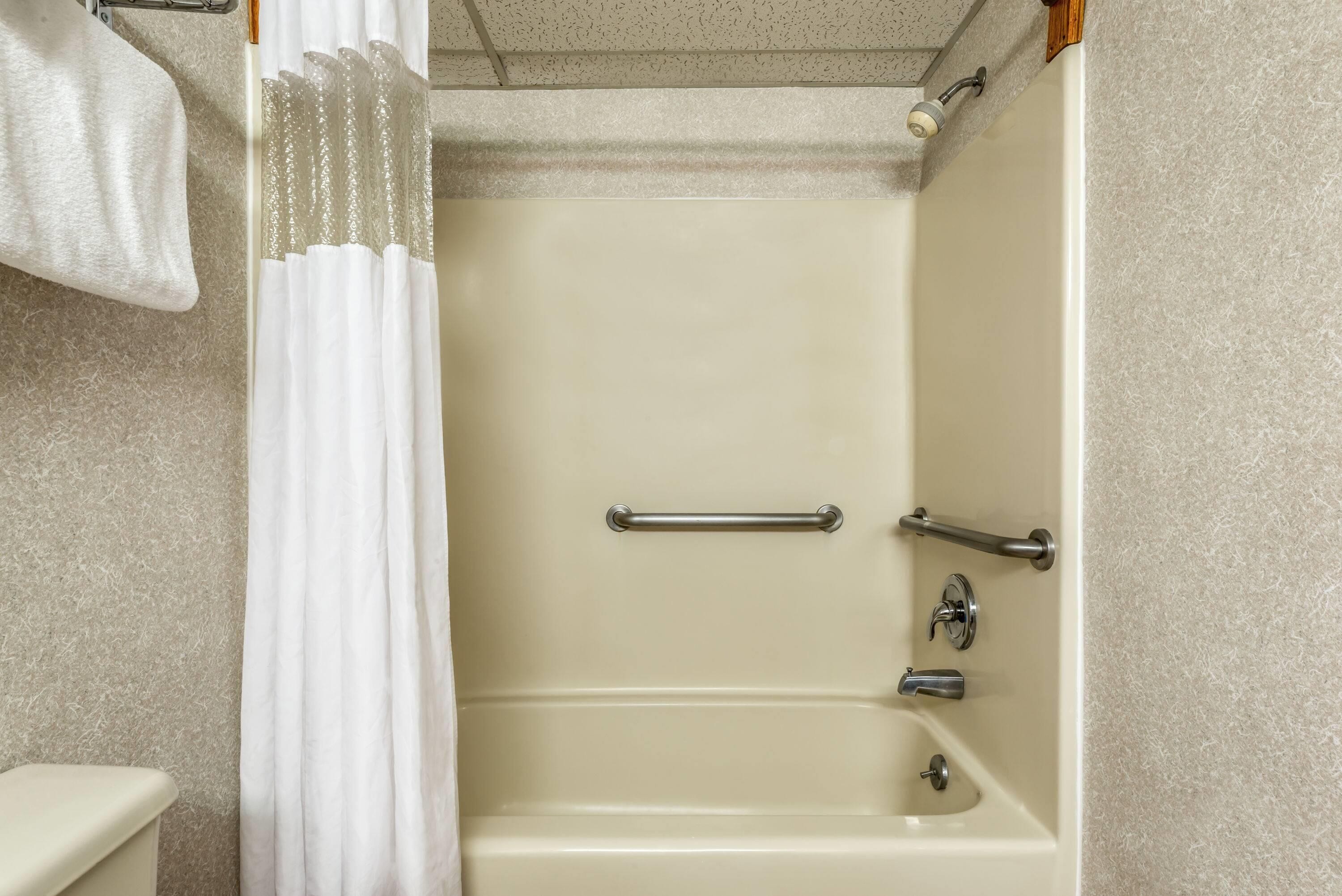 Ein Badezimmer mit Badewanne, Toilette und Duschvorhang.