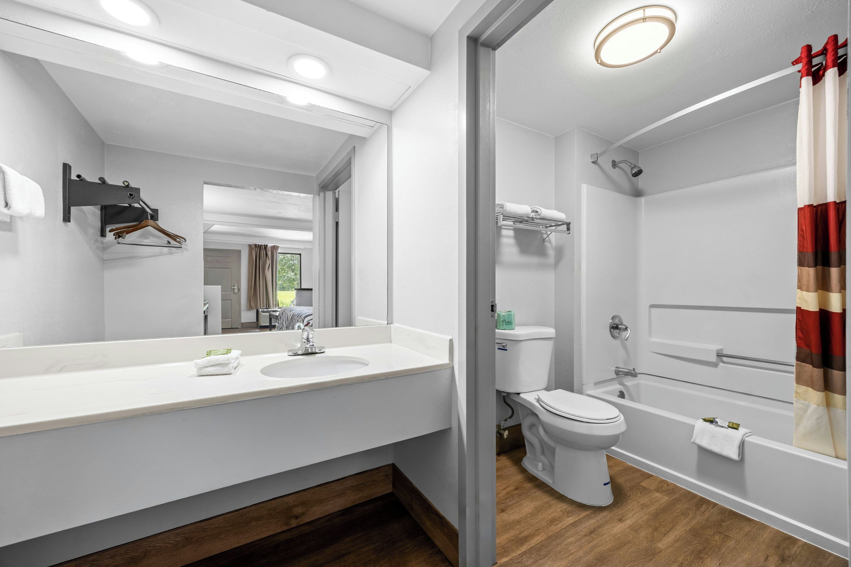 A modern bathroom with a vanity, sink, mirror, toilet, and shower.
