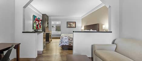 Habitación de hotel con cama, sofá, escritorio y televisor.