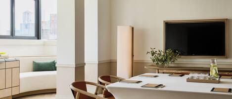 Un comedor moderno con una mesa grande, sillas y un televisor de pantalla plana.