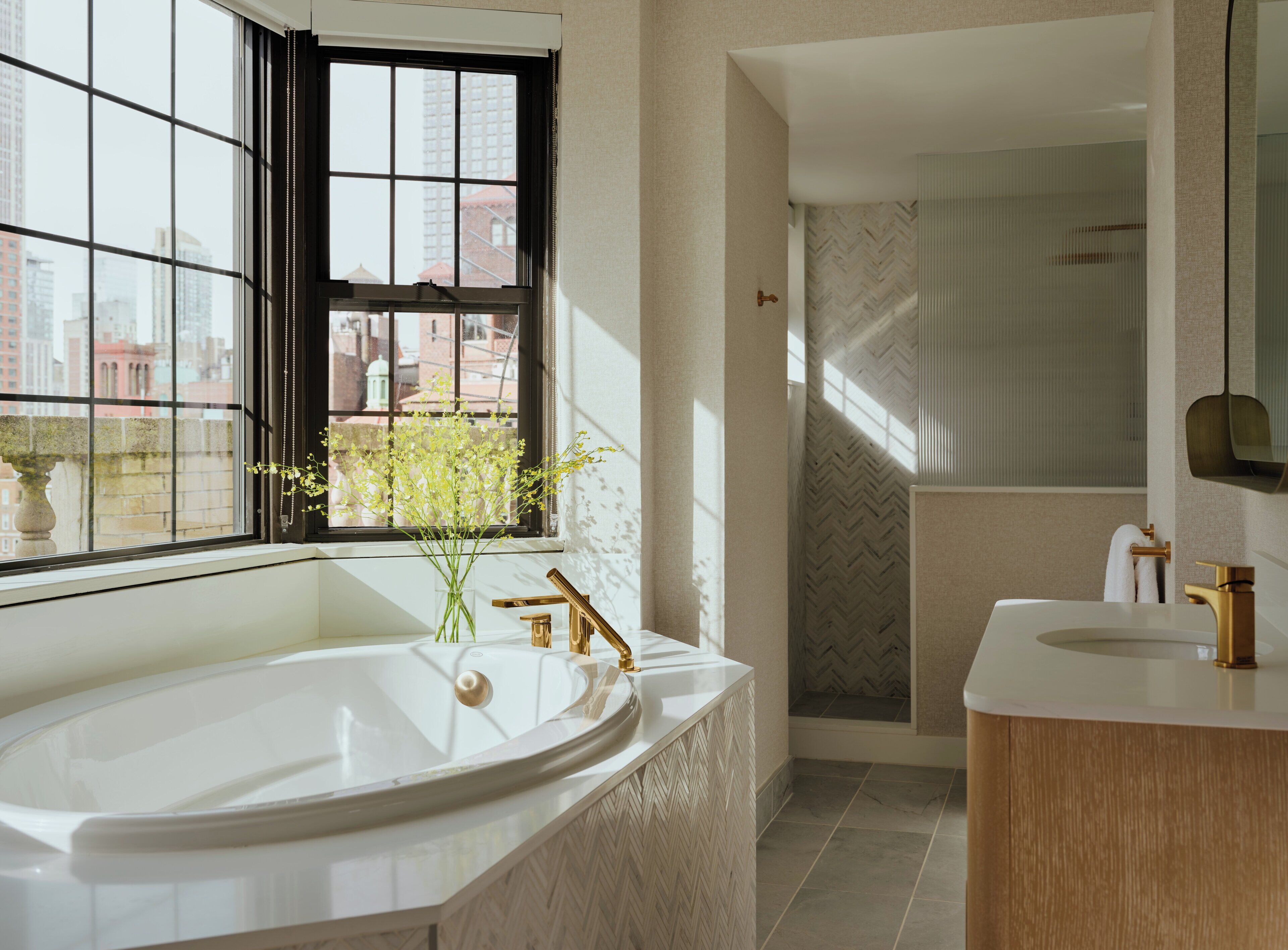 A modern bathroom with a freestanding bathtub, a vanity with a mirror, and a shower area.