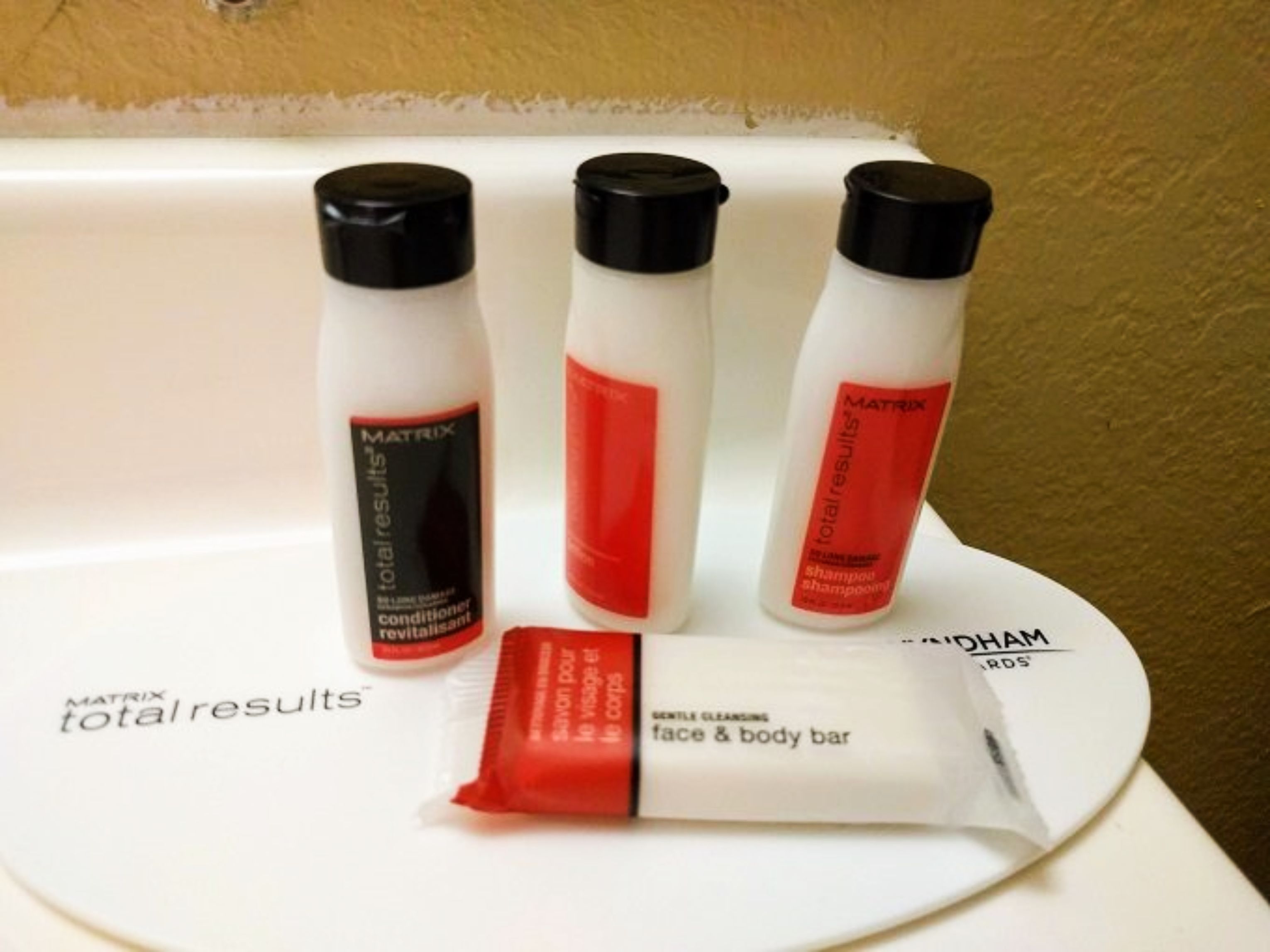 A tray with three bottles of Matrix Total Results hair care products and a bar of face and body bar soap.