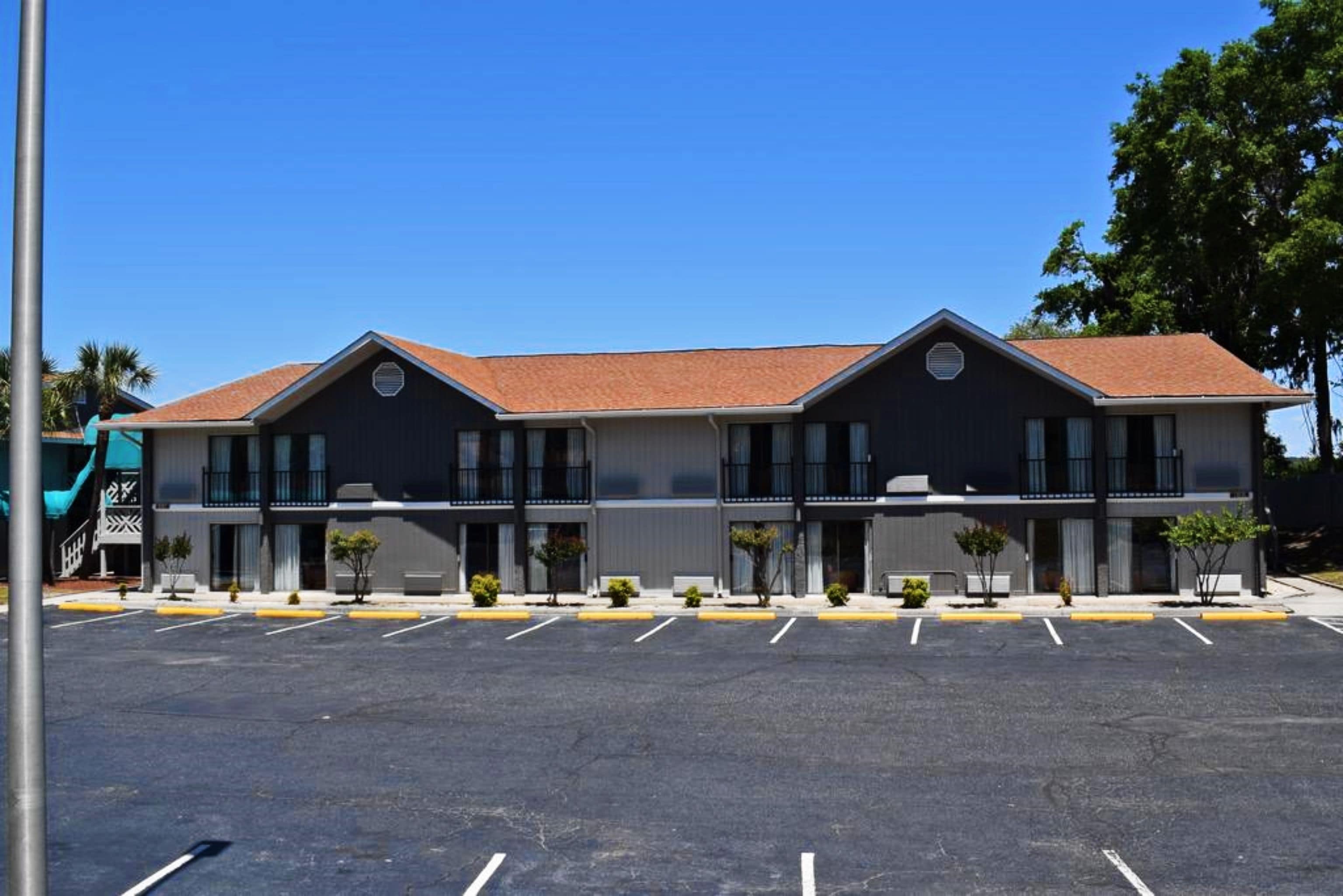 A two-story building with a parking lot in front.