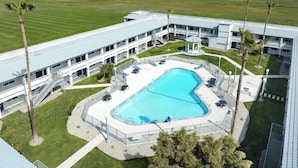 A hotel with a swimming pool, outdoor seating, and a view of the surrounding landscape. - Spark by Hilton Santa Nella on I-5 (Gustine)