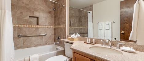 Un baño moderno con bañera, inodoro, lavabo y tocador.