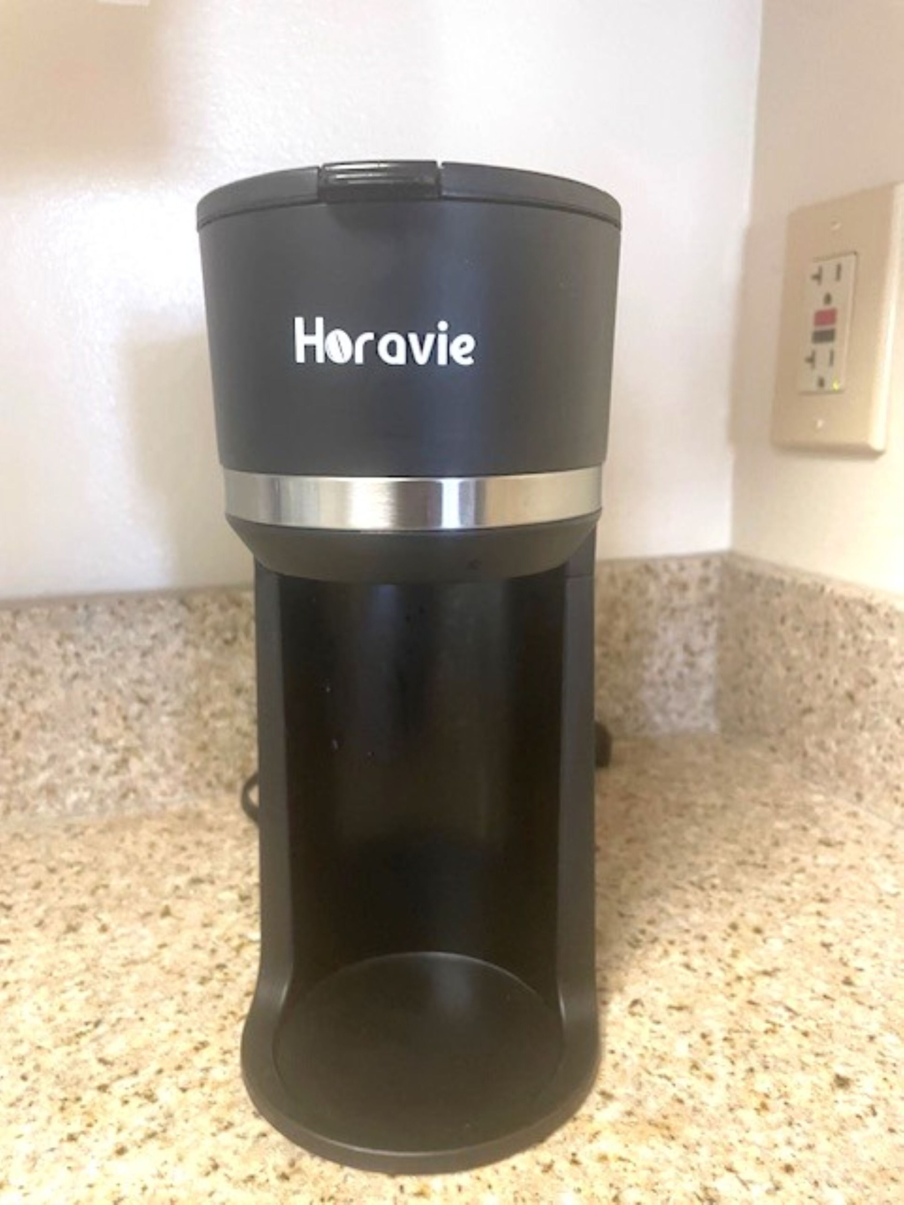 A black coffee maker with the brand name "Horavie" on a kitchen countertop.