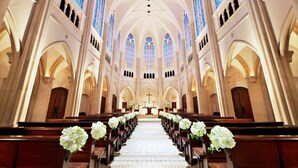 A church interior with pews, altar, and stained glass windows.