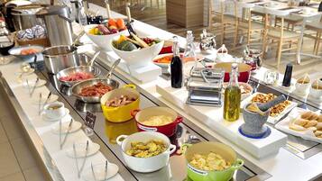 A buffet setup with various food items and utensils.