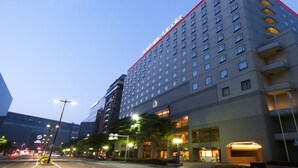 A multi-story hotel with a modern design, featuring a prominent red trim at the top.