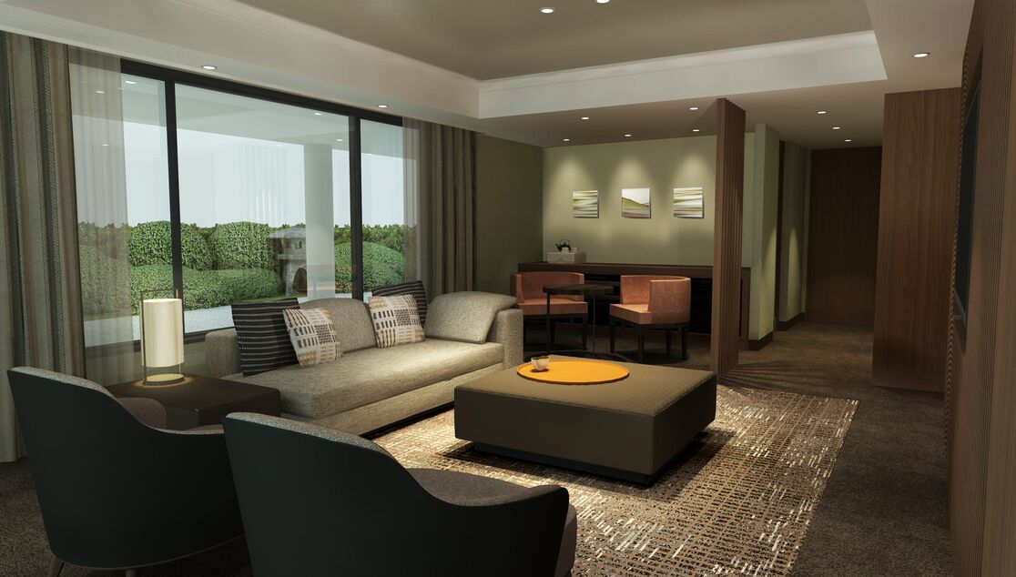 Ein modernes Hotelzimmer mit einer Couch, Sesseln, einem Couchtisch und einem Essbereich.