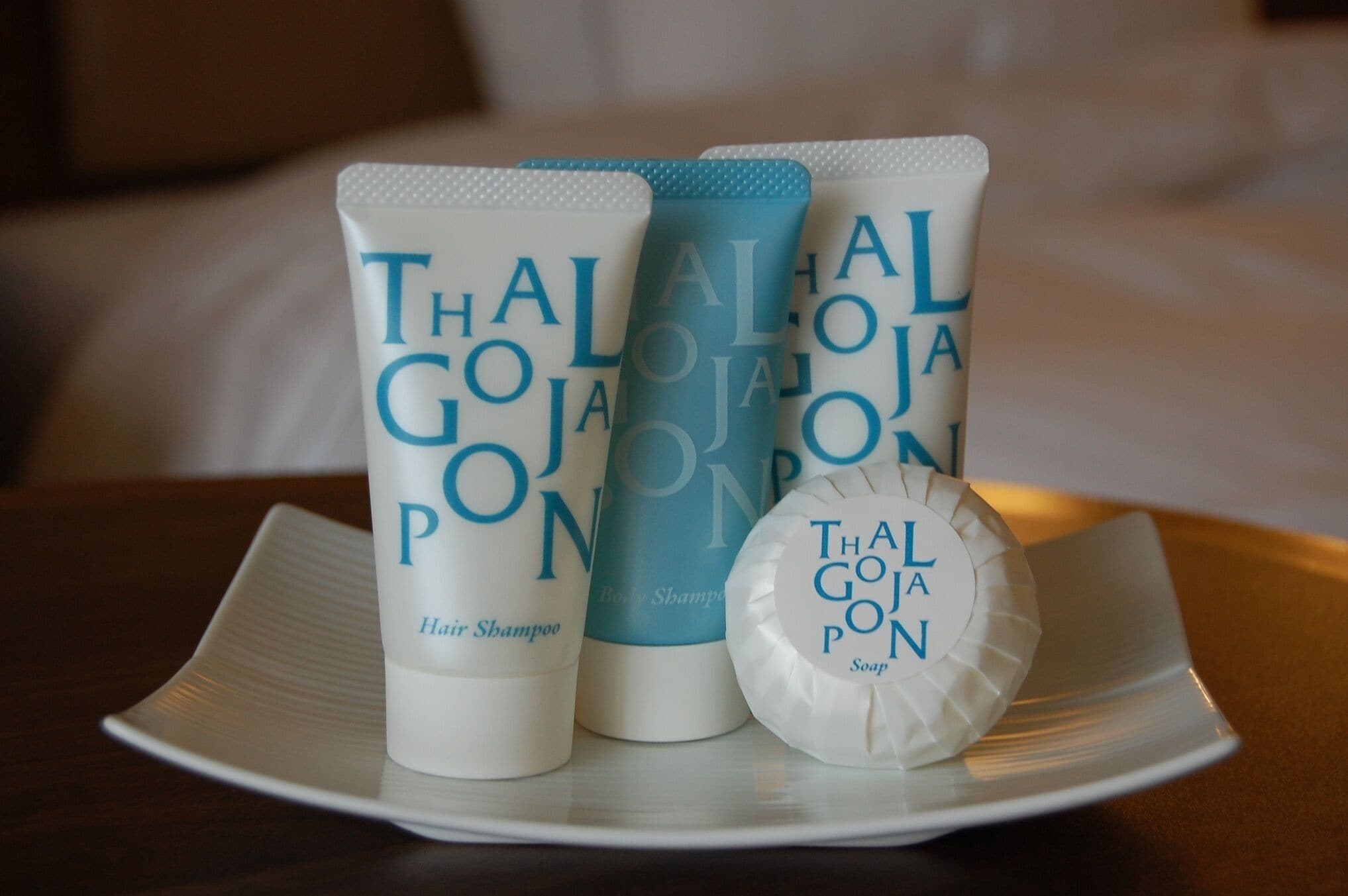 A set of Thal Goja PON hair and body care products on a white plate.