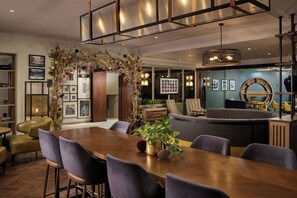 Un espace repas moderne avec une table en bois, des chaises rembourrées et un arc décoratif.