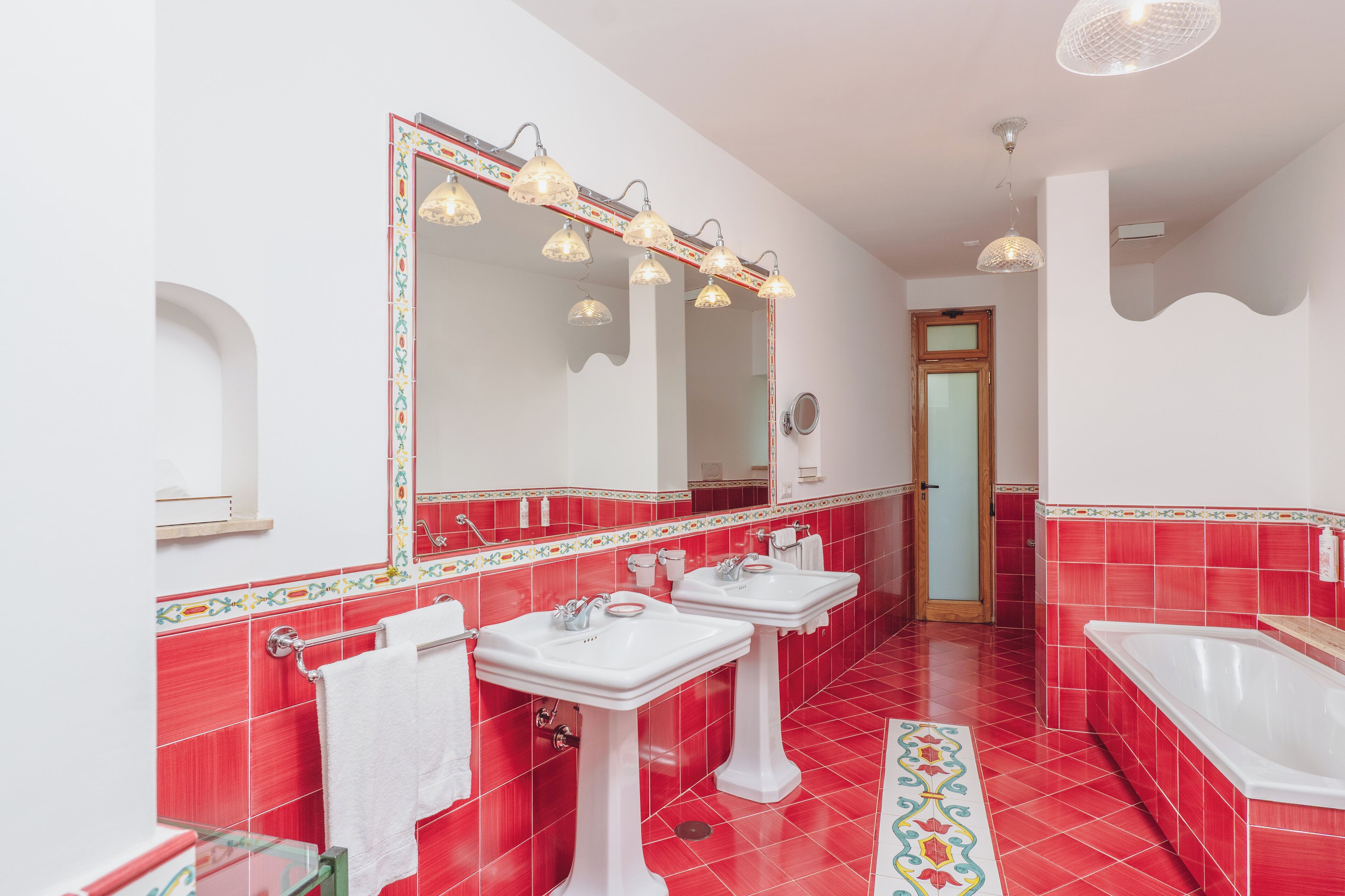 Un baño con dos lavamanos, un espejo grande y una bañera.