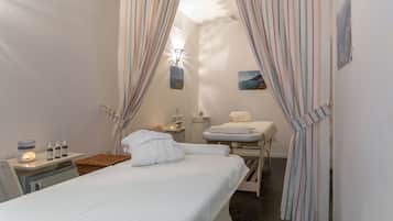 Cozy retreat with a single bed, bedside table, and chair, offering a serene sea view.