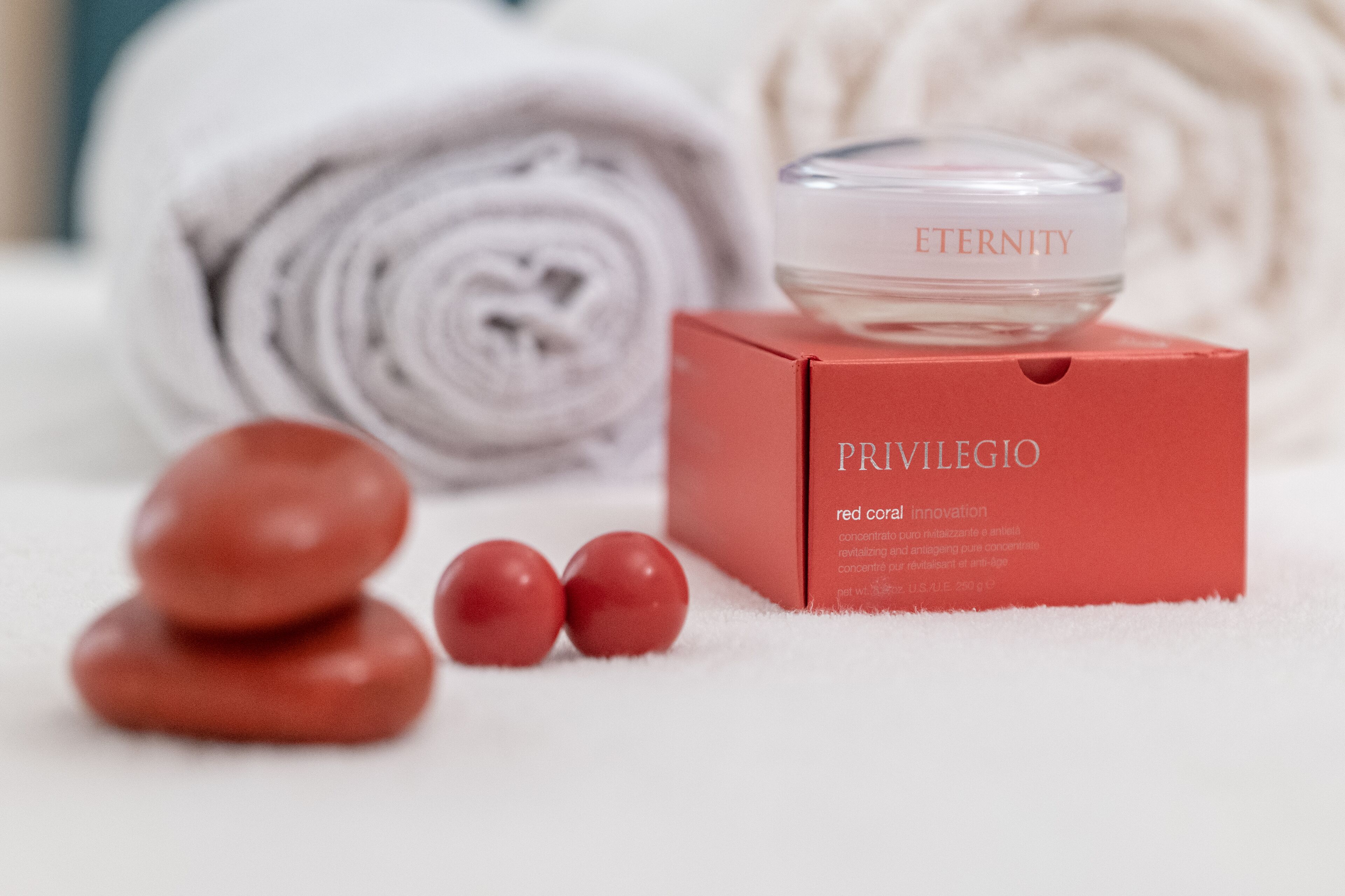 A spa setting with a red box labeled "PRIVILEGIO" and a jar labeled "ETERNITY".
