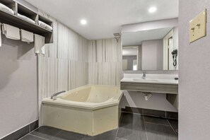A modern bathroom with a freestanding bathtub, a vanity with a sink, and a mirror above the sink.