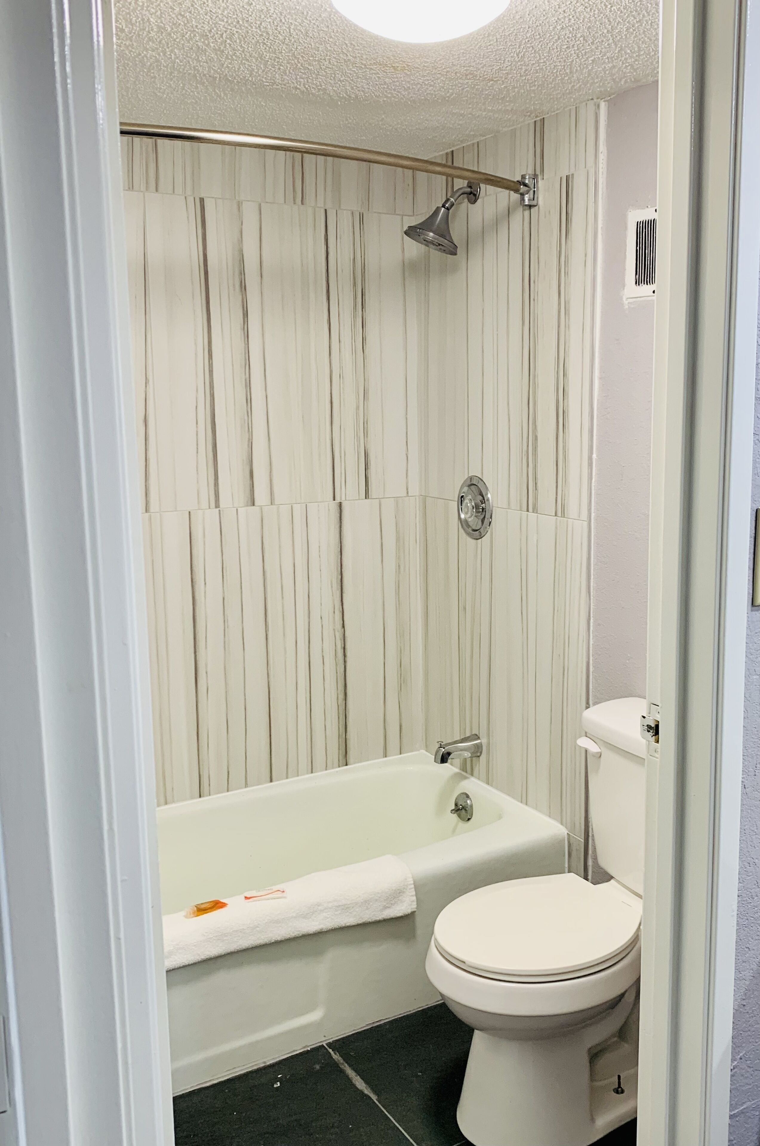 Un baño con bañera, inodoro y ducha.
