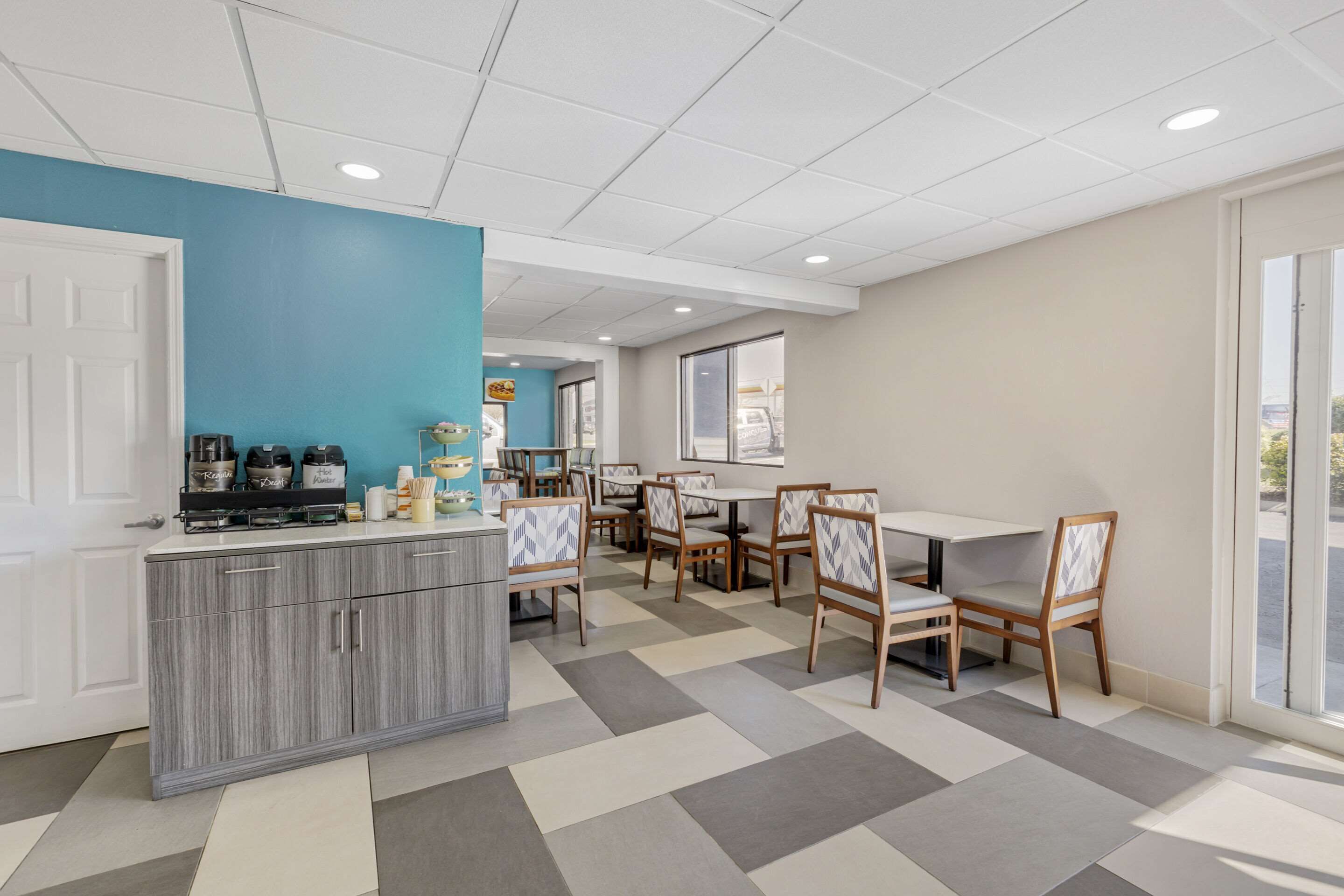 Un espace repas moderne comprenant un comptoir de cuisine, plusieurs tables et des chaises.