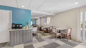 Un espace repas moderne comprenant un comptoir de cuisine, plusieurs tables et des chaises.