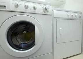 Een voorzichtszicht van een witte wasmachine met een voorlaadklep en bedieningspaneel.