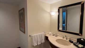 Un baño con lavabo, espejo, toallero y un cuadro en la pared.