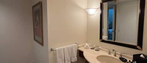 A bathroom with a sink, mirror, towel rack, and a framed picture on the wall.