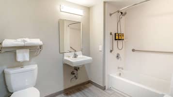 Ein Badezimmer mit Toilette, Waschbecken, Spiegel, Dusche und Badewanne.