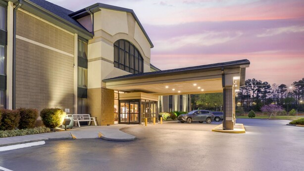 A hotel entrance with a covered driveway, a car parked inside, and a well-lit building facade. - Best Western Plus Knoxville Cedar Bluff (Knoxville)