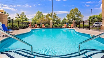 Een buitenzwembad en ligstoelen