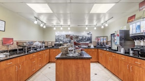 A spacious kitchen with wooden cabinets, a central island, and various appliances. - Best Western Plus Knoxville Cedar Bluff (Knoxville)