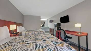 Une chambre d’hôtel avec deux lits, un bureau, une chaise, une télévision et une lampe.