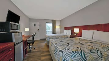 Une chambre d’hôtel avec deux lits, un bureau équipé d’un ordinateur et d’un micro-ondes, ainsi qu’une petite télévision.