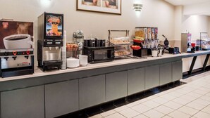 A self-service breakfast bar with coffee machines, a microwave, and various food options. - Ramada by Wyndham Columbia (Columbia)