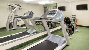 A gym with treadmills, elliptical machines, and a stationary bike. - Ramada by Wyndham Columbia (Columbia)