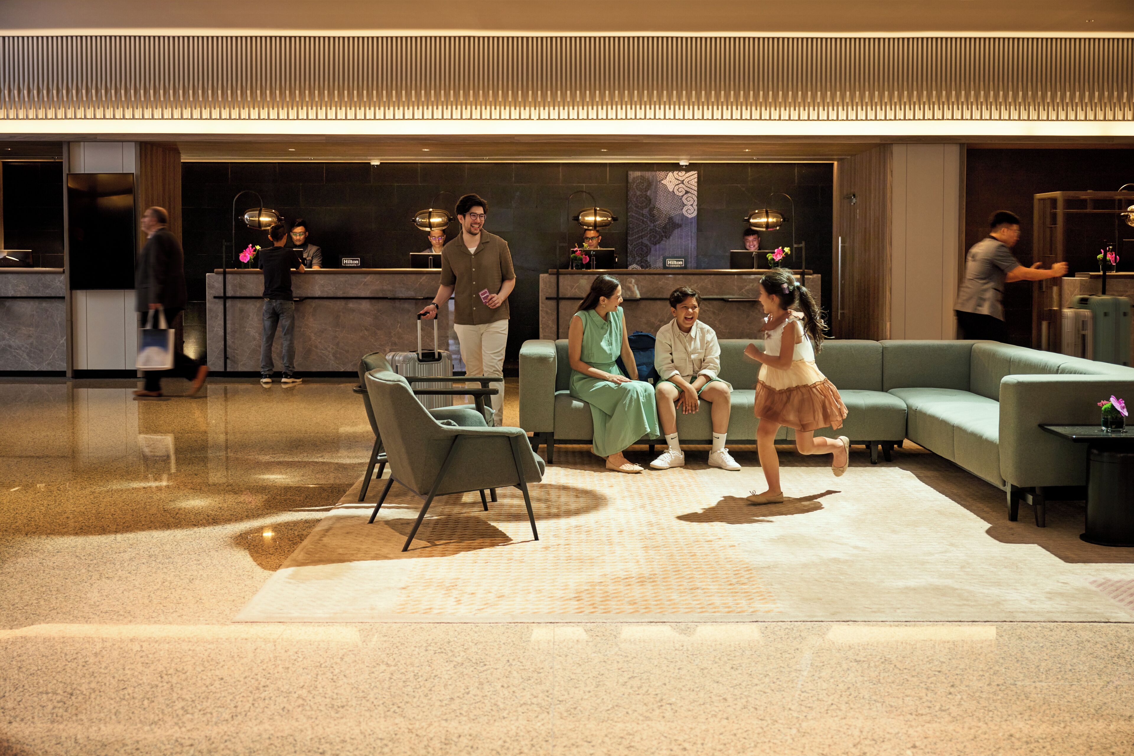 Eine Lobby mit Empfangsschreibtisch, Sitzbereich und Check-in-Schalter.