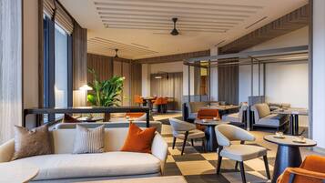 A modern hotel lobby with a checkered floor, sofas, chairs, and tables.