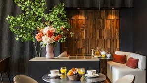 Un comedor moderno con una mesa redonda, sillas y un florero.