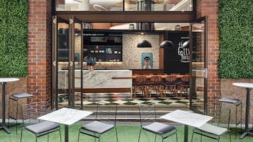 An indoor seating area with tables and chairs, a counter with a menu, and a wall with a poster.