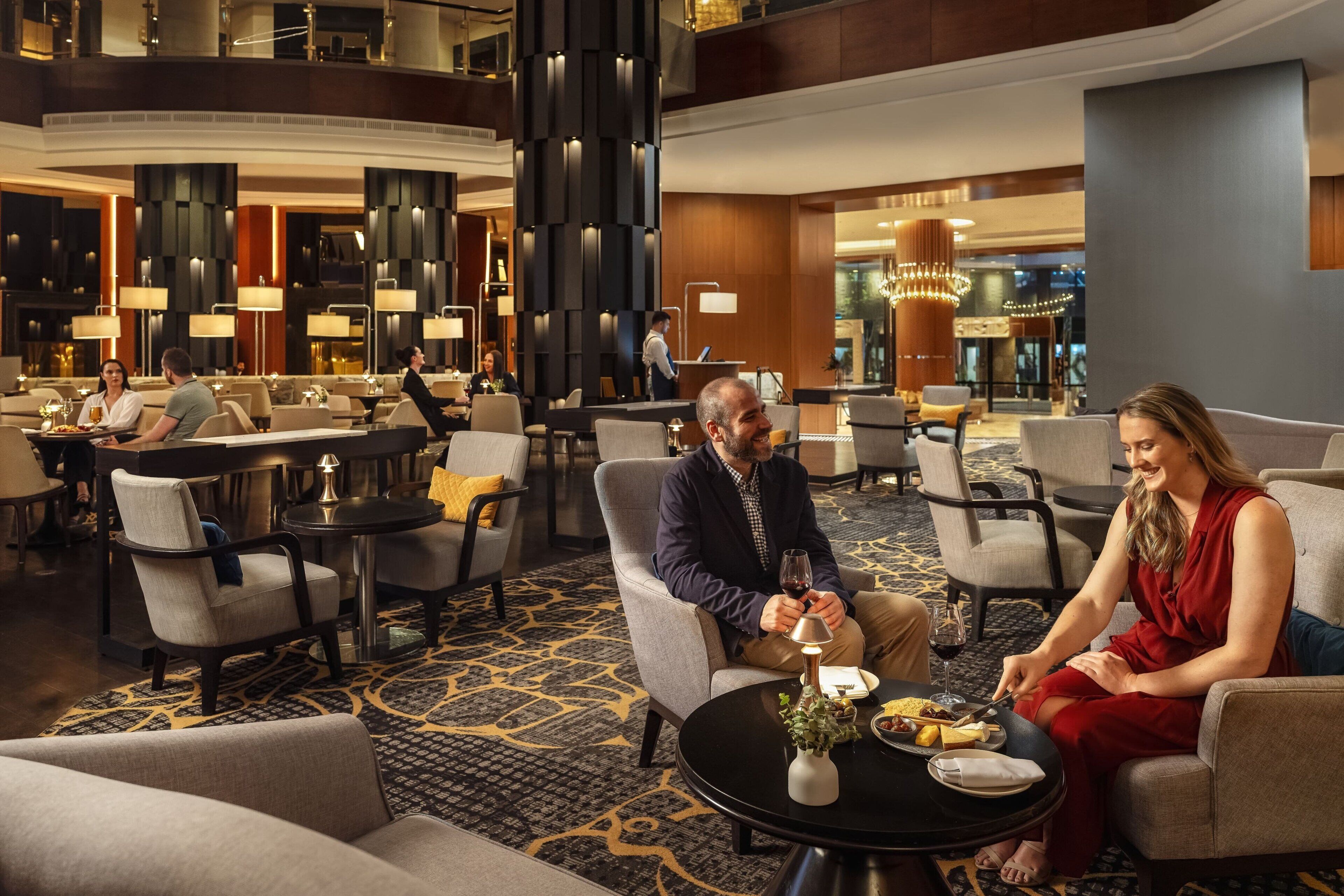 Un moderno vestíbulo de hotel con asientos cómodos, una mesa de recepción y un ambiente bien iluminado.