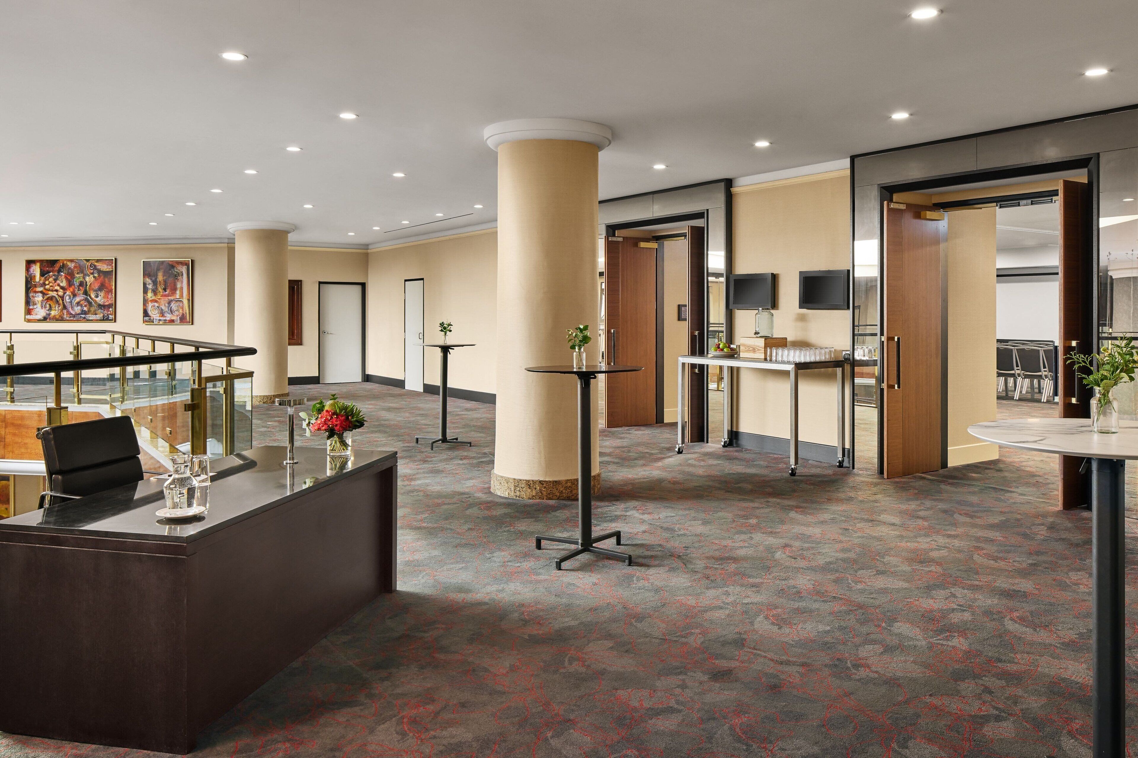 Vestíbulo de hotel con mostrador de recepción, zona de estar y comedor.