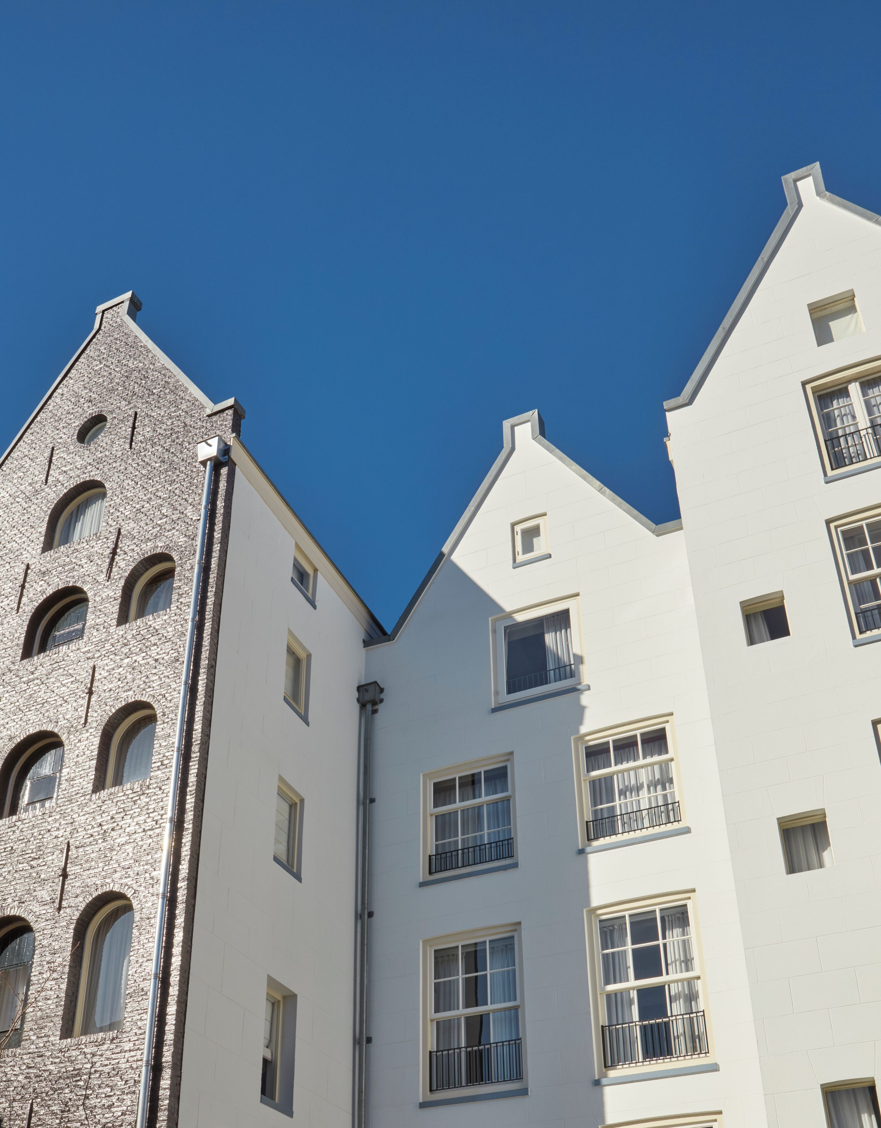 A building with a mix of architectural styles, including a stone facade and white-painted sections.